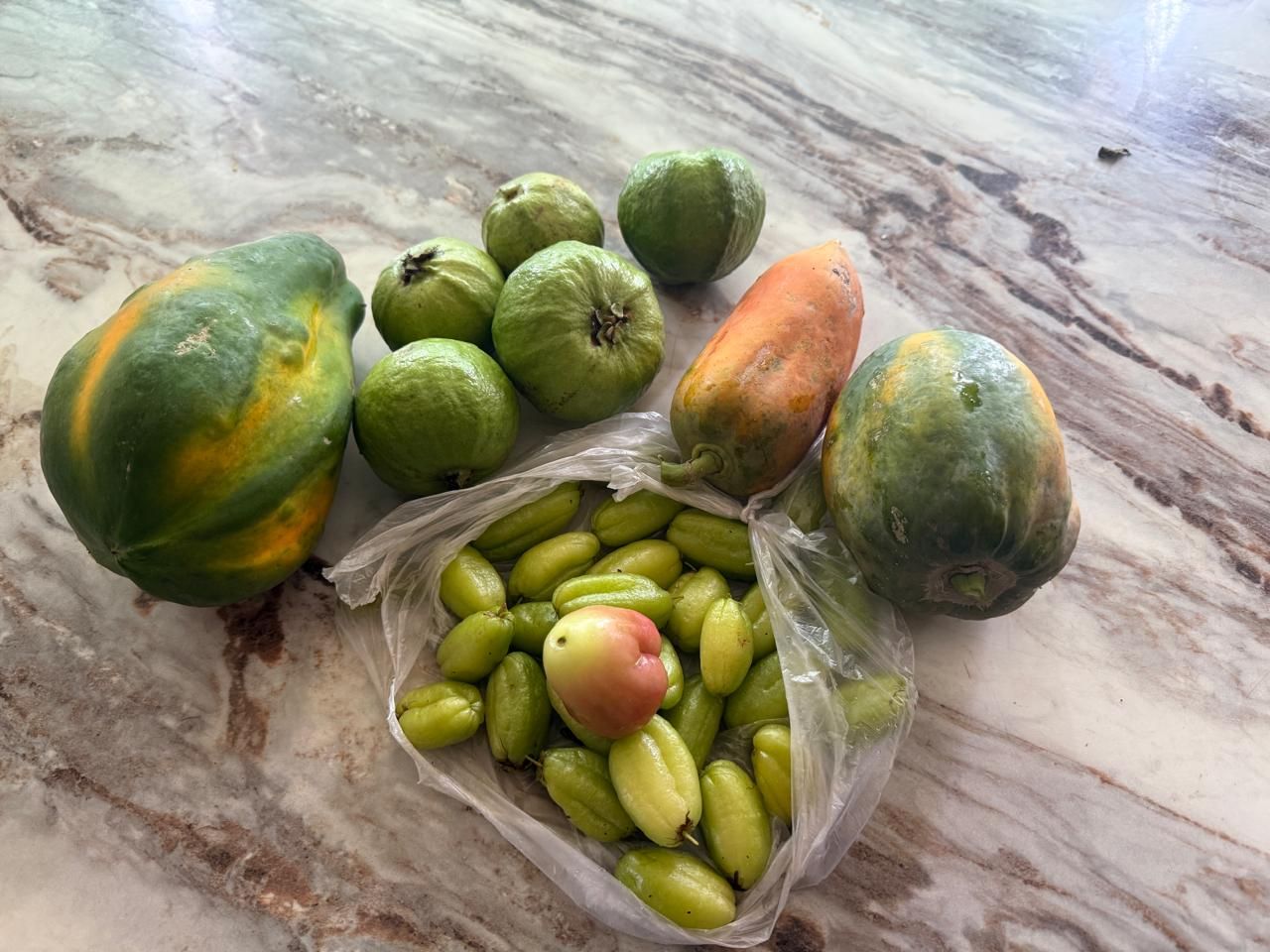 Papayas, guavas and other fresh fruits on a table